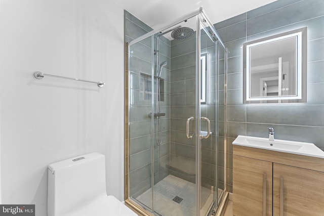 full bathroom featuring a stall shower, vanity, and toilet