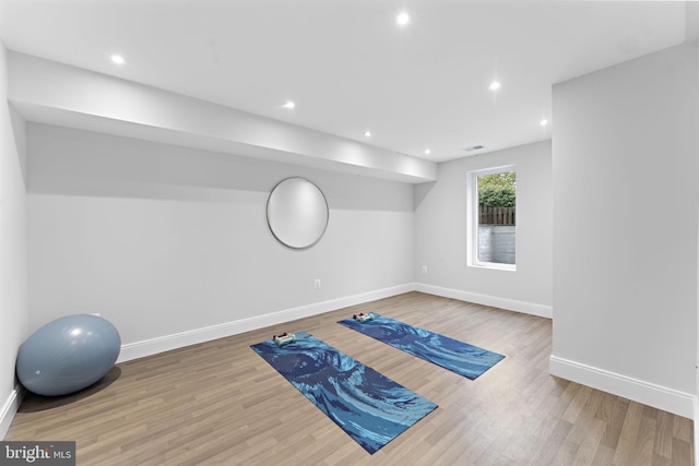 exercise area featuring recessed lighting, wood finished floors, visible vents, and baseboards