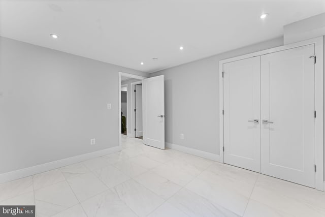 unfurnished bedroom featuring baseboards, a closet, and recessed lighting