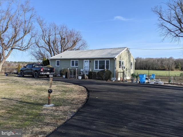 view of front of house with metal roof and a front lawn