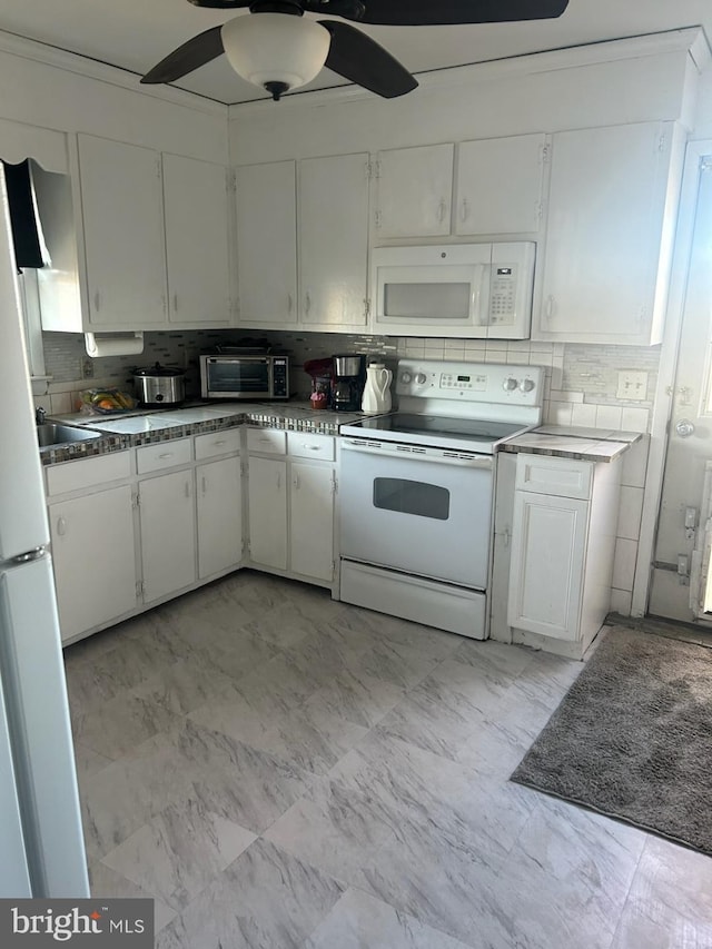 kitchen featuring decorative backsplash, white appliances, and white cabinets