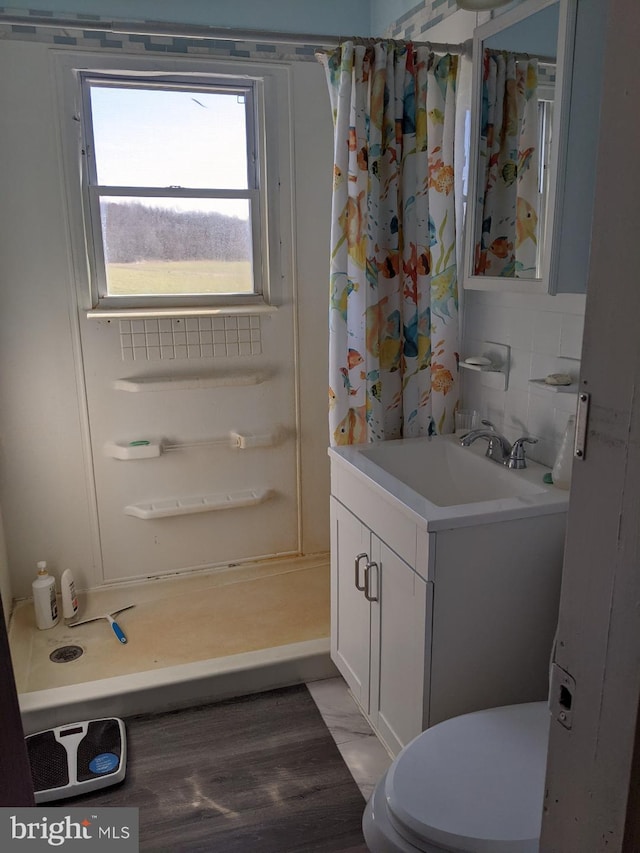 bathroom featuring curtained shower, toilet, vanity, and tasteful backsplash