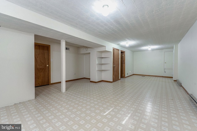 basement featuring a textured ceiling and built in features