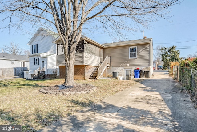 rear view of house with a yard and cooling unit