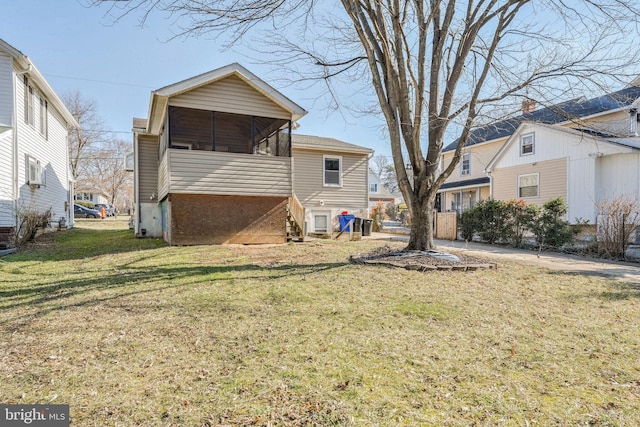 back of property featuring a yard and a sunroom