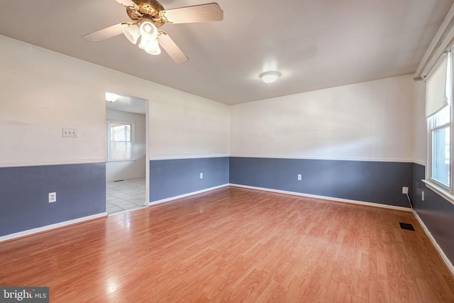 empty room with ceiling fan and light hardwood / wood-style floors