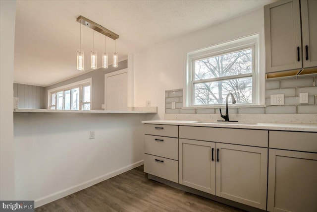 kitchen featuring gray cabinets, sink, pendant lighting, and dark hardwood / wood-style floors