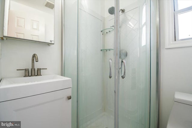 bathroom with an enclosed shower, vanity, and toilet