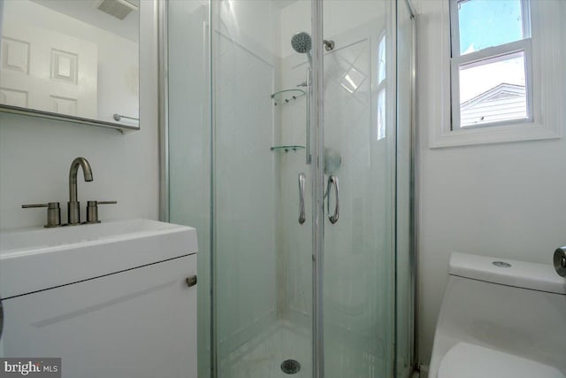 bathroom with vanity, an enclosed shower, and toilet