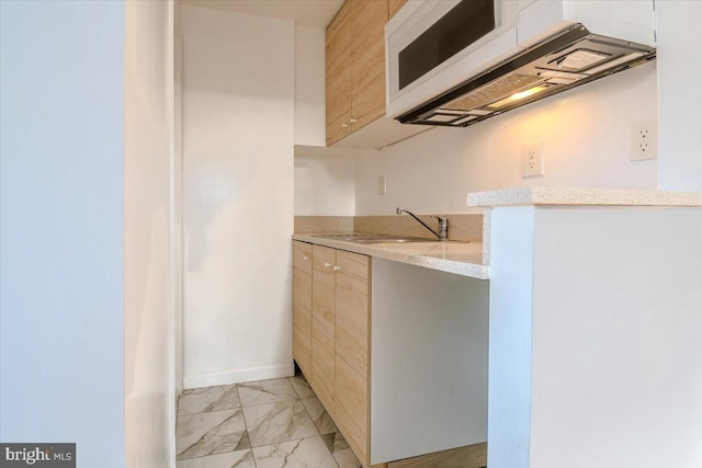 kitchen featuring sink and light stone countertops