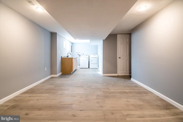 interior space featuring sink, independent washer and dryer, and light wood-type flooring