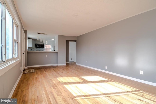 unfurnished living room with light hardwood / wood-style flooring and a wealth of natural light