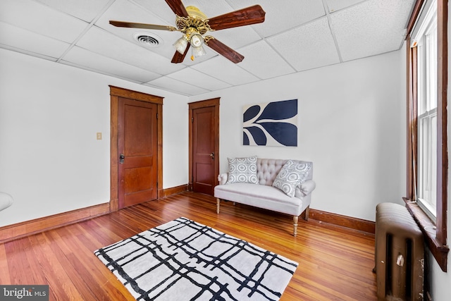 2902 Shirey Ave, Baltimore, MD 21214 - living area featuring radiator, baseboards, hardwood / wood-style flooring, healthy amount of natural light, and a paneled ceiling