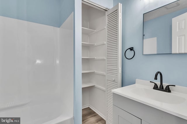 bathroom with  shower combination, a closet, vanity, and wood finished floors