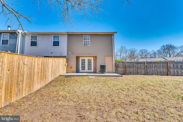 back of property with a lawn, a patio, a fenced backyard, french doors, and central air condition unit