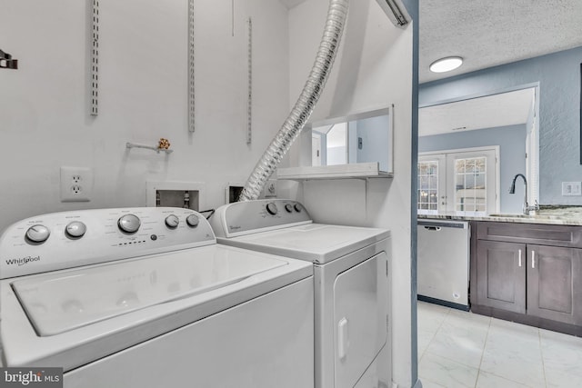 laundry area featuring washing machine and clothes dryer, marble finish floor, a textured ceiling, french doors, and a sink