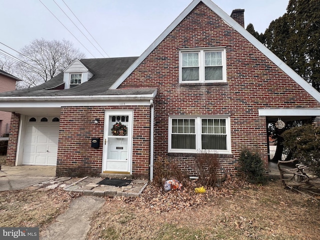 traditional home featuring driveway, brick siding, and an attached garage