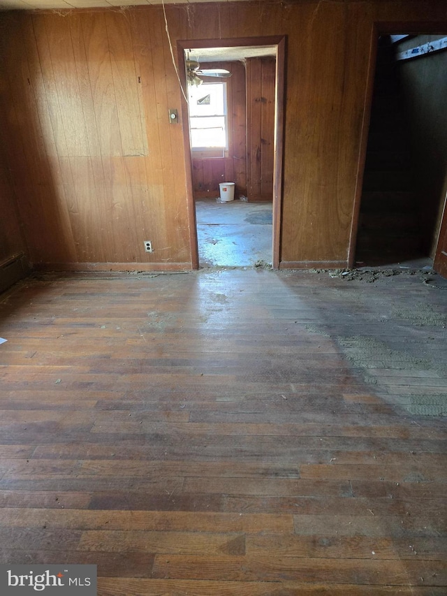 empty room with wooden walls and dark hardwood / wood-style floors