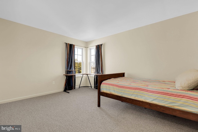 carpeted bedroom featuring baseboards