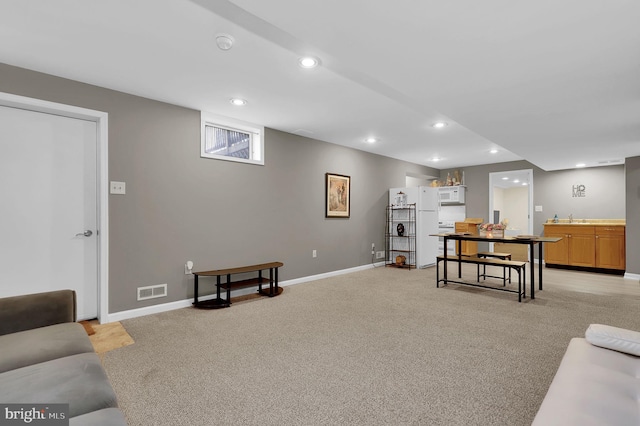 living room with baseboards, recessed lighting, and light colored carpet