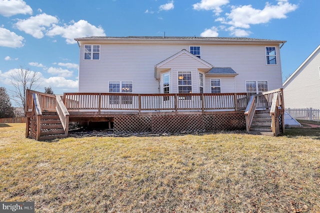 rear view of house with a deck and a yard