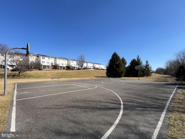 view of basketball court with community basketball court and a lawn