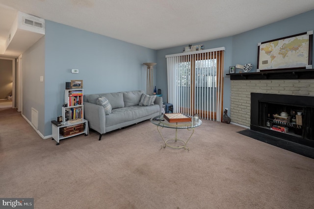 living area with carpet floors, a fireplace, visible vents, and a textured ceiling