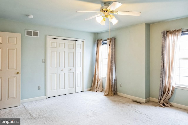 unfurnished bedroom featuring a closet, visible vents, baseboards, and multiple windows