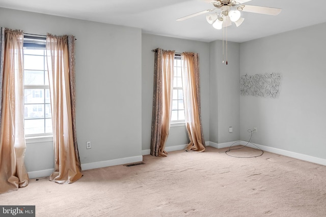 carpeted empty room with a wealth of natural light, visible vents, and baseboards