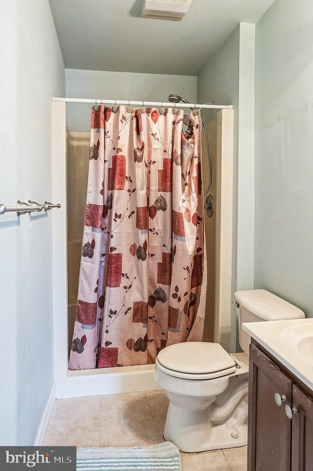 full bathroom featuring toilet, a stall shower, tile patterned flooring, and vanity