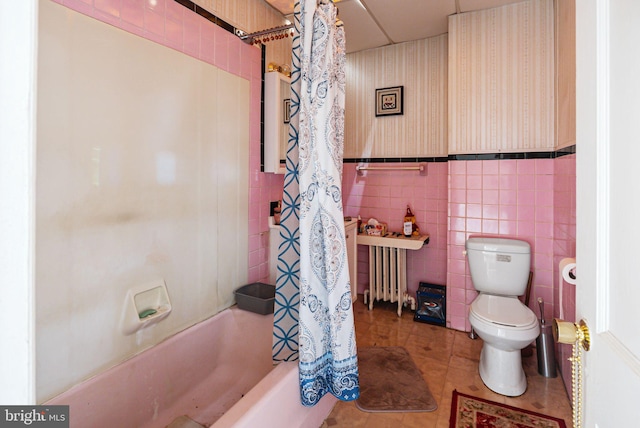 bathroom with radiator, tile patterned flooring, toilet, shower / tub combo, and tile walls