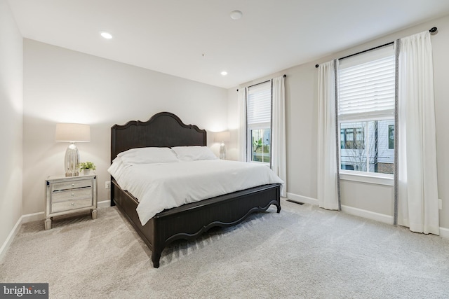 bedroom featuring baseboards, multiple windows, recessed lighting, and light colored carpet