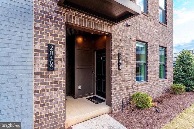 doorway to property with brick siding