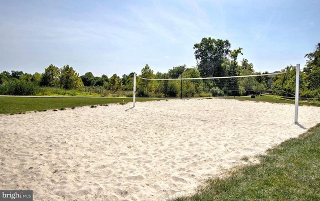 view of community with a lawn and volleyball court