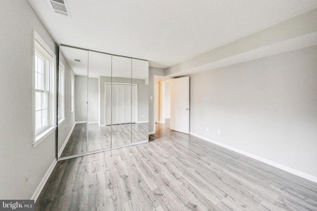 unfurnished bedroom featuring a closet and light hardwood / wood-style flooring