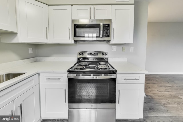 kitchen featuring white cabinets, stainless steel appliances, and hardwood / wood-style floors