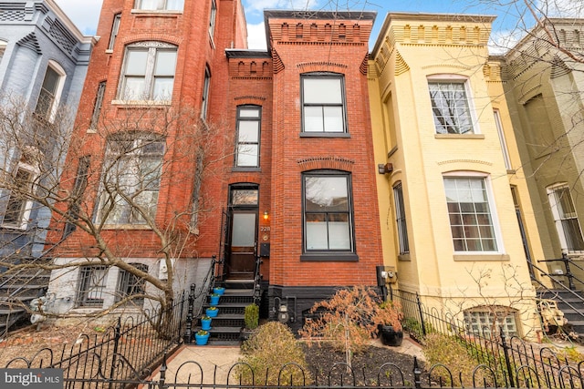 multi unit property featuring brick siding and fence