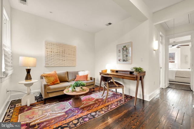 interior space featuring visible vents, dark wood-style flooring, attic access, and baseboards