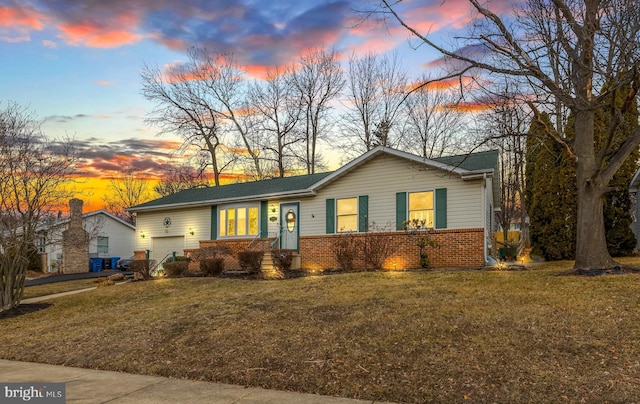 ranch-style house with a garage and a lawn