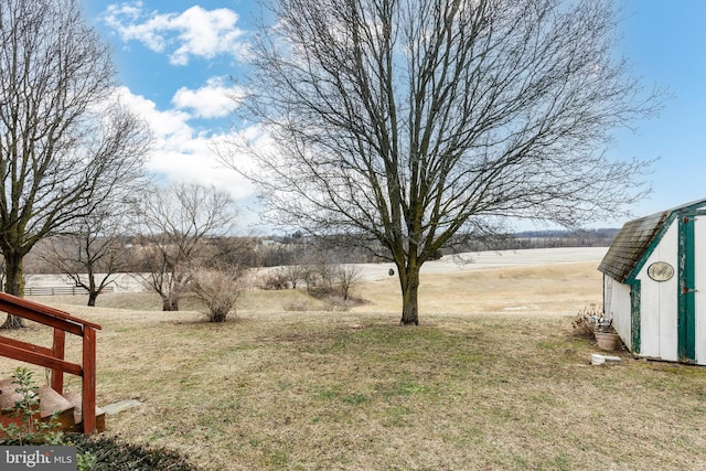 view of yard featuring a storage shed and a rural view