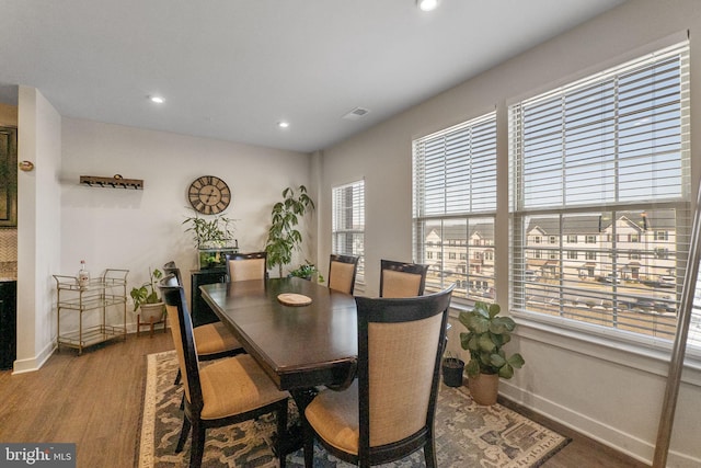 dining room featuring baseboards, visible vents, wood finished floors, and recessed lighting