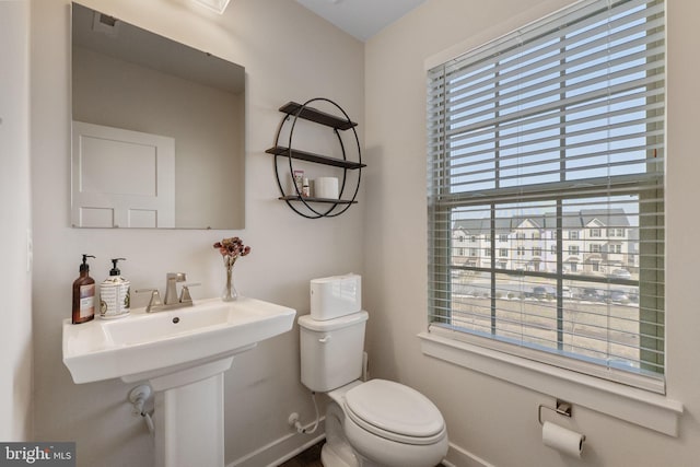 half bathroom with toilet and baseboards