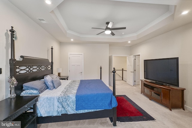 bedroom featuring light carpet, visible vents, a tray ceiling, and recessed lighting