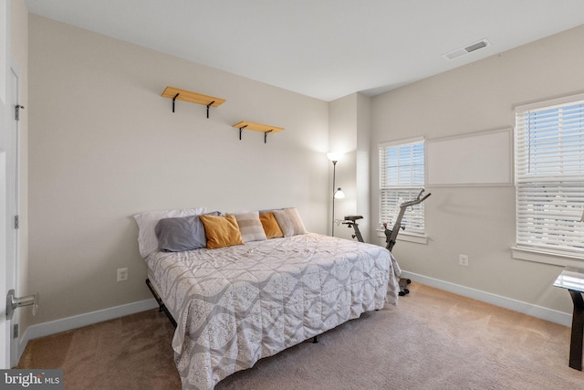 carpeted bedroom with visible vents and baseboards