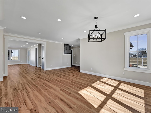 interior space featuring a notable chandelier, ornamental molding, and wood-type flooring