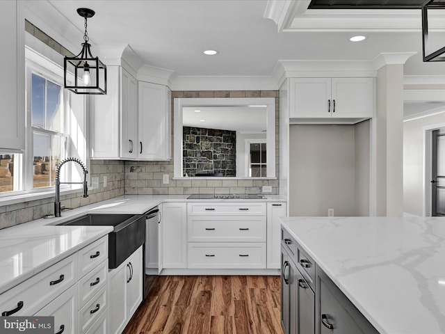 kitchen featuring white cabinetry, pendant lighting, light stone countertops, and crown molding