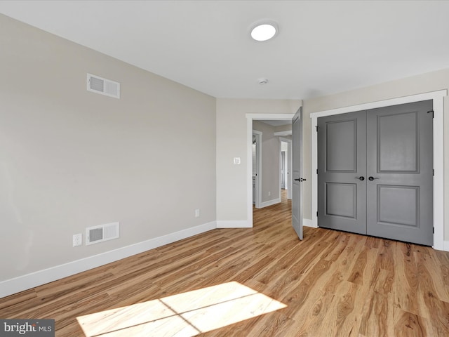 unfurnished bedroom with light hardwood / wood-style flooring and a closet