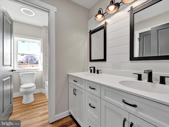 bathroom featuring toilet, hardwood / wood-style flooring, and vanity