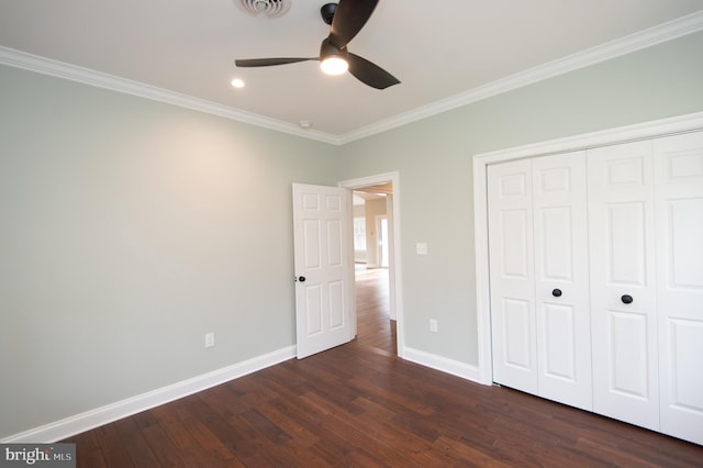 unfurnished bedroom featuring crown molding, a closet, baseboards, and dark wood-type flooring