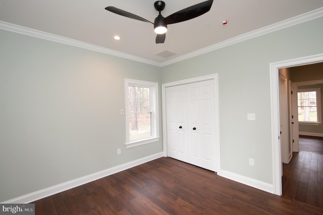 unfurnished bedroom featuring visible vents, baseboards, dark wood-style floors, crown molding, and a closet